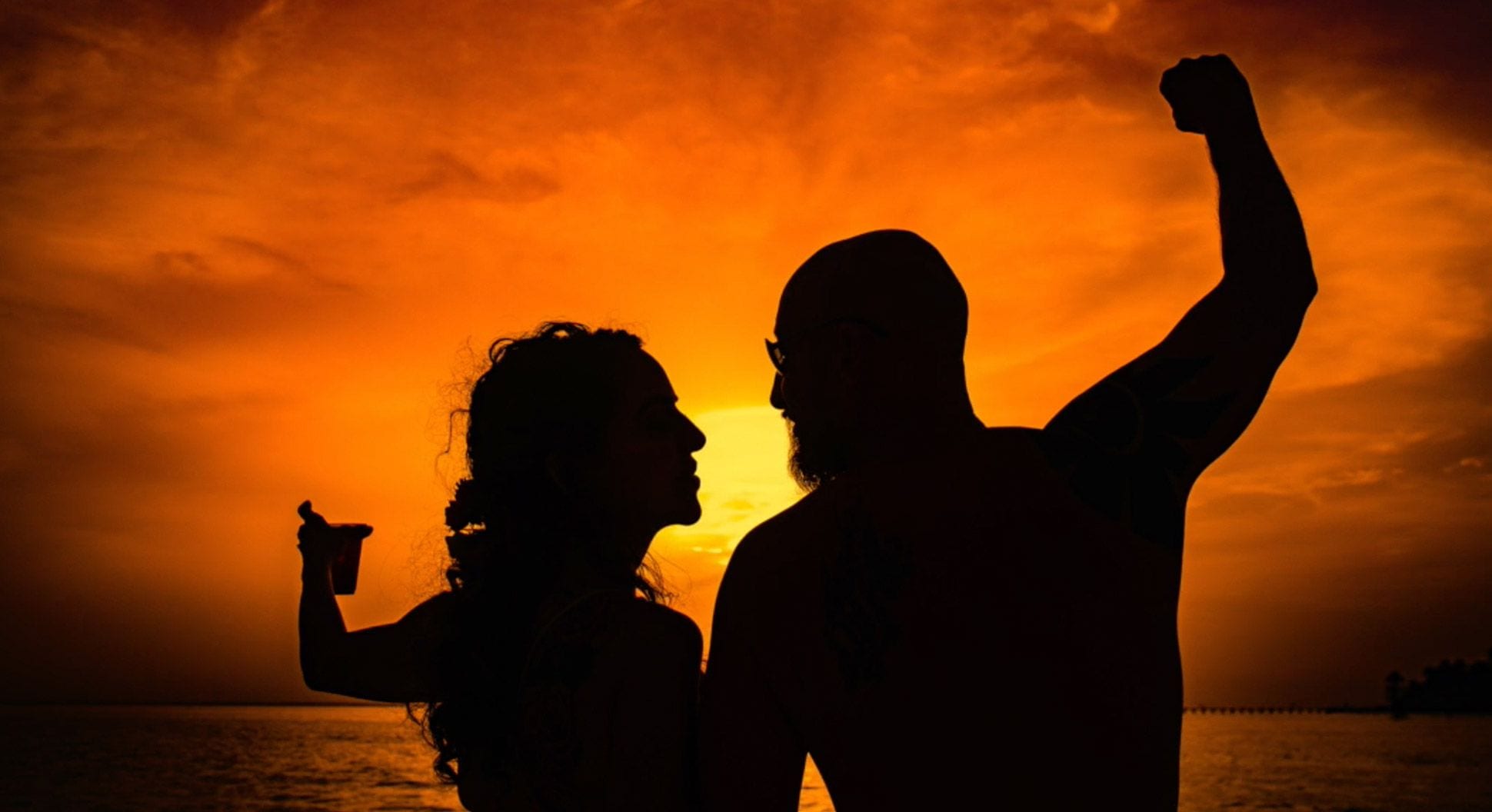 Michelle and her husband toasting sunset on the beach